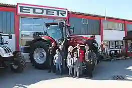 Gruppenbild vor einem roten Case Traktor